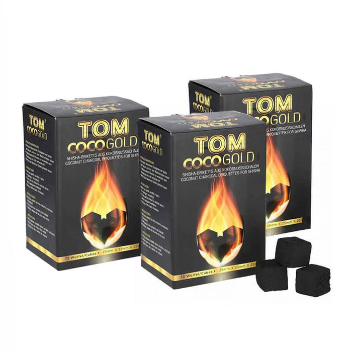 Three boxes of Tom Cococha Gold coconut charcoal with loose cube-shaped pieces in front.